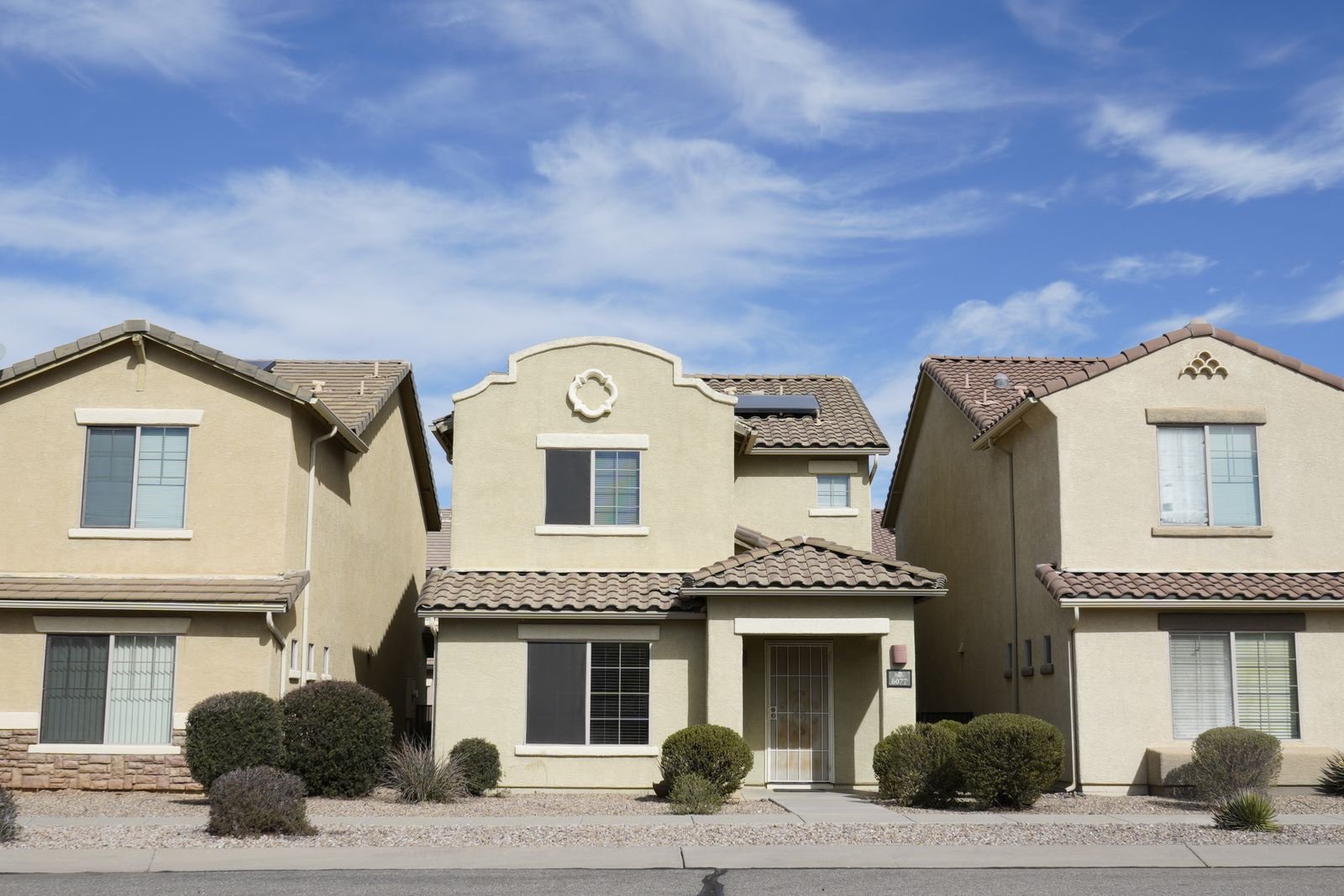 Row of stucco houses with tile roofs in a Southwestern subdivision