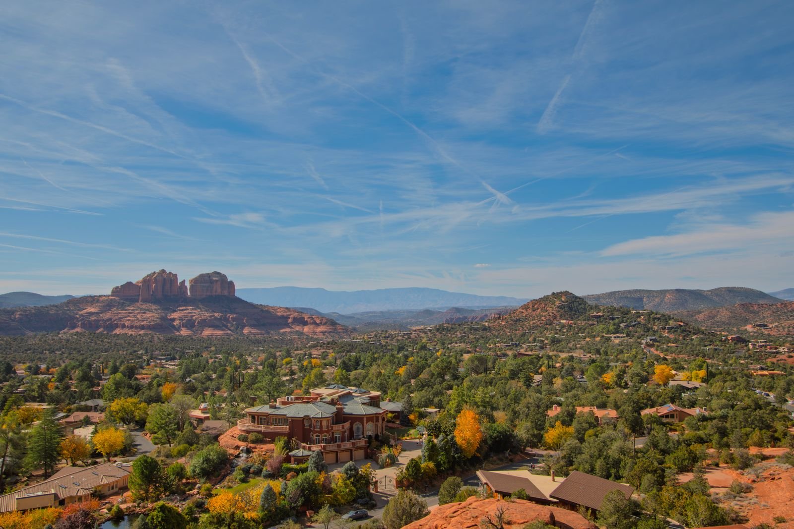 Red rock country with a town spread across the valley below