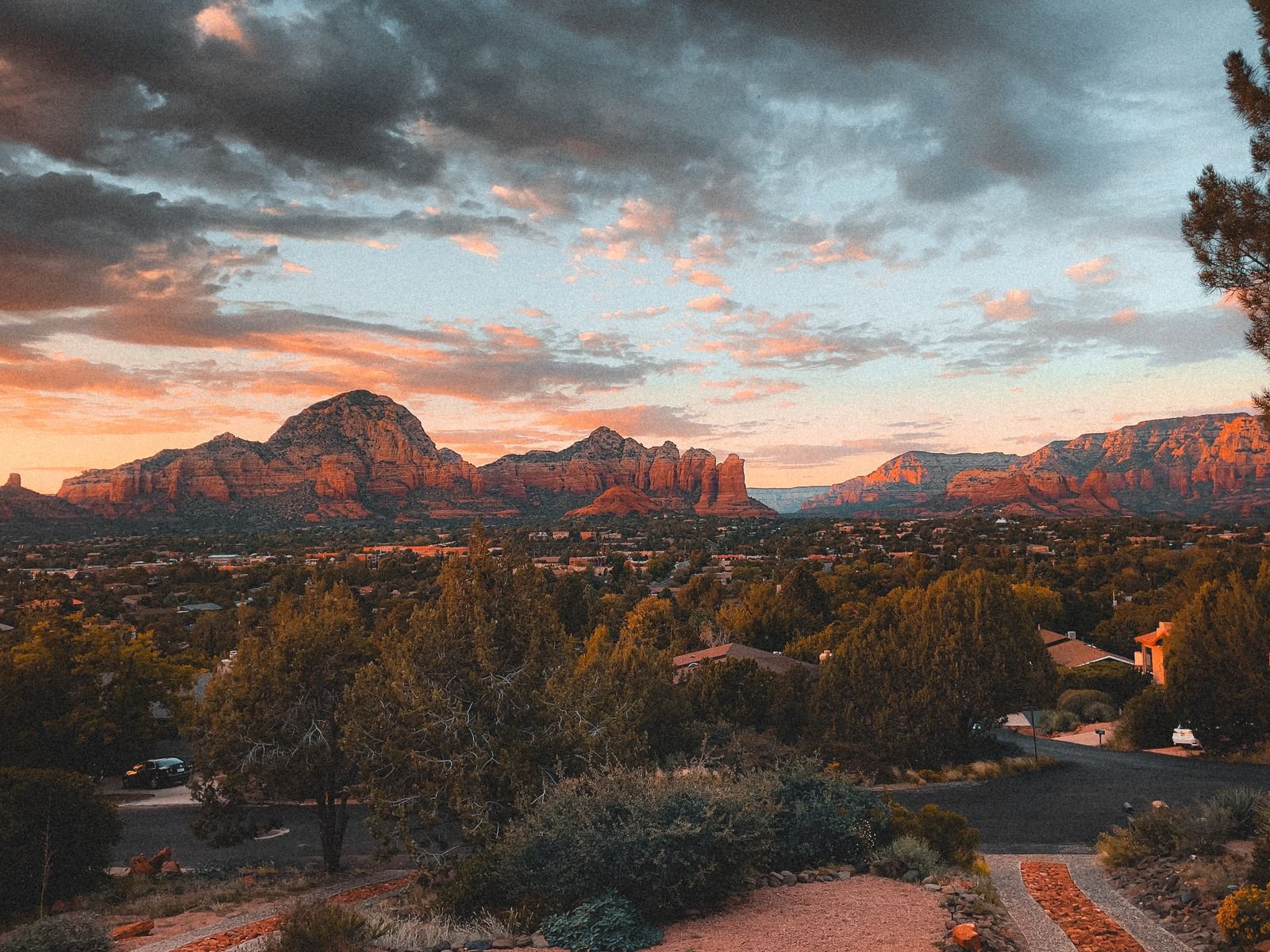 Red rock formations at sunset above wooded country