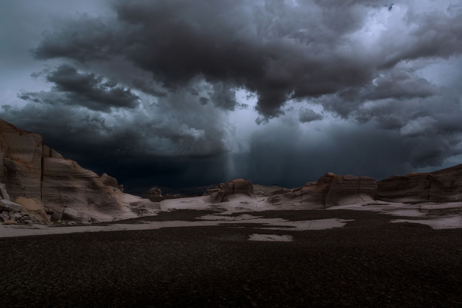 Dark storm clouds gathering over rocky desert terrain